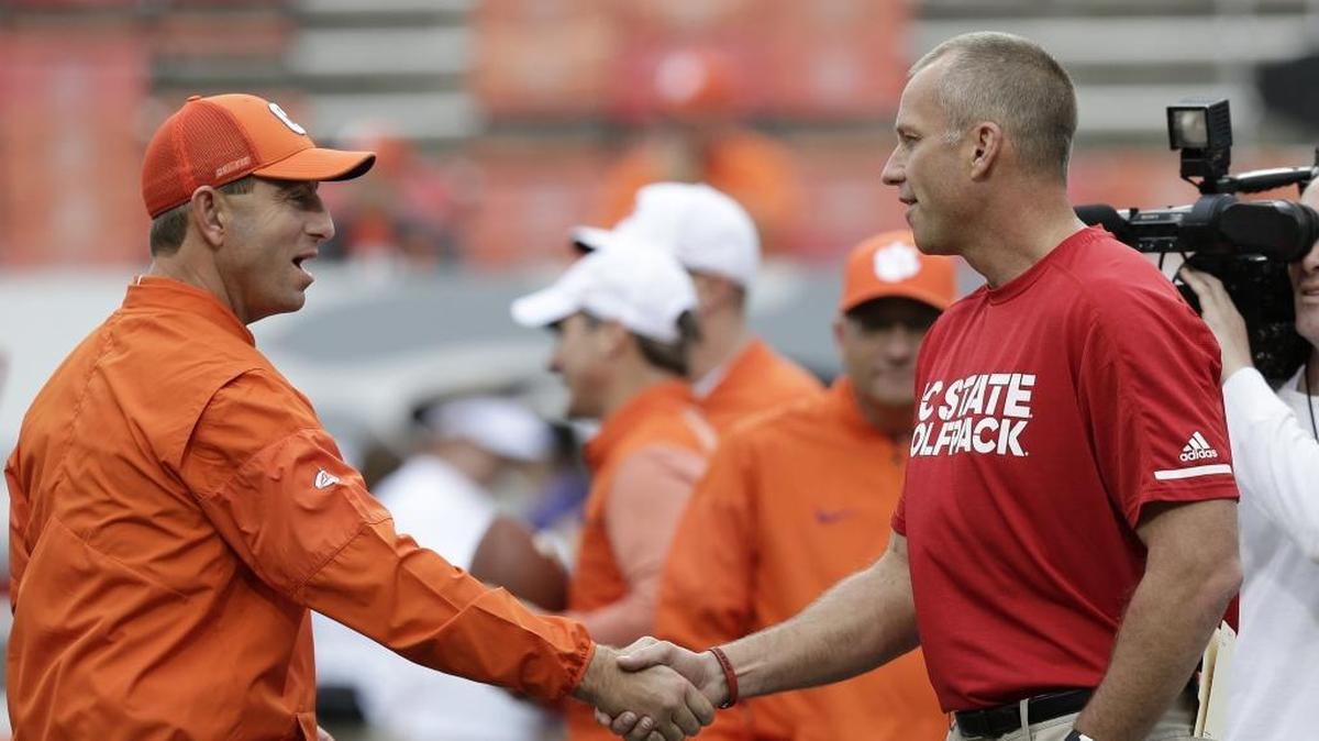 After Dabo Swinney’s, left, Clemson Tigers beat N.C. State 38-31 Saturday, Wolfpack head coach Dave Doeren, right, saw a picture of a laptop on the Clemson bench, and asked the ACC to investigate.