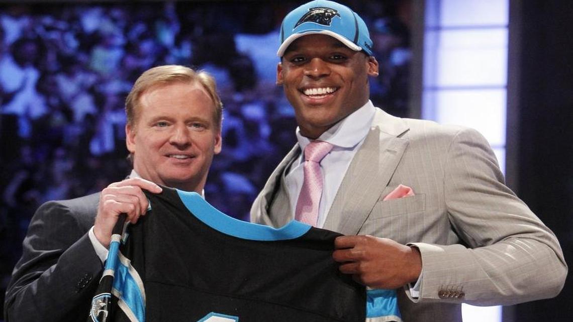 Cam Newton, right, holds up a jersey with NFL commissioner Roger Goodell after he was selected as the No. 1 overall pick by the Carolina Panthers in the first round of the NFL football draft on April 28, 2011, in New York.
