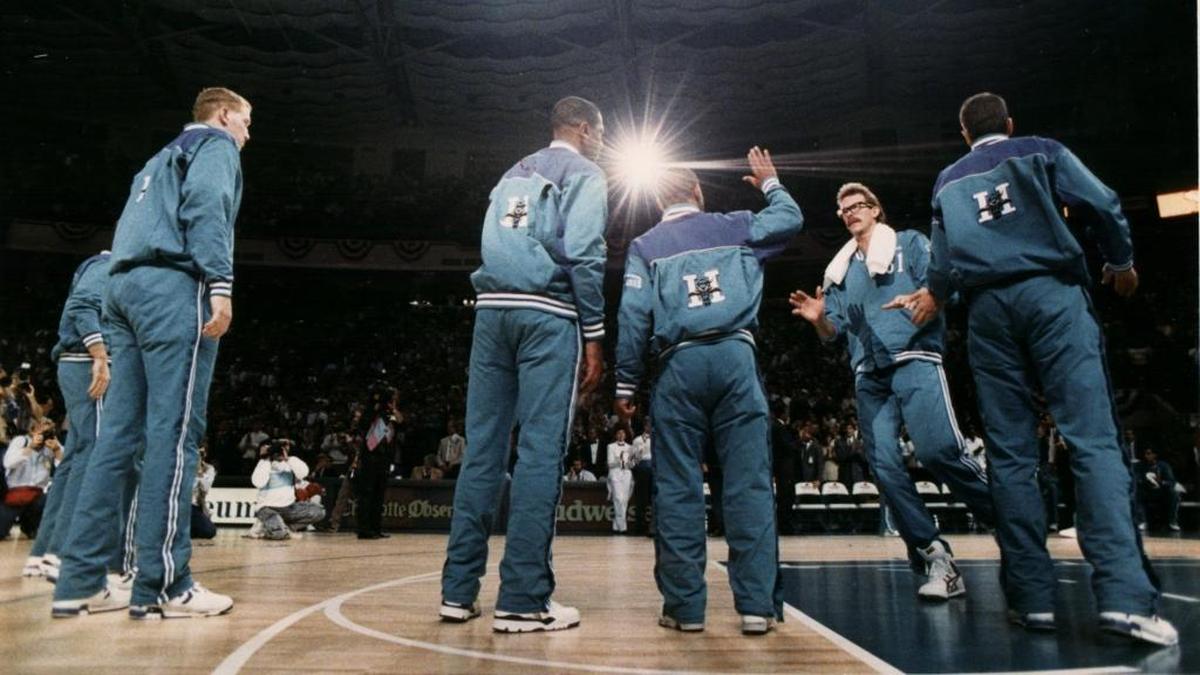 The Charlotte Hornets’ Kurt Rambis (facing the camera) gets a high-five from Muggsy Bogues on opening night in 1988.