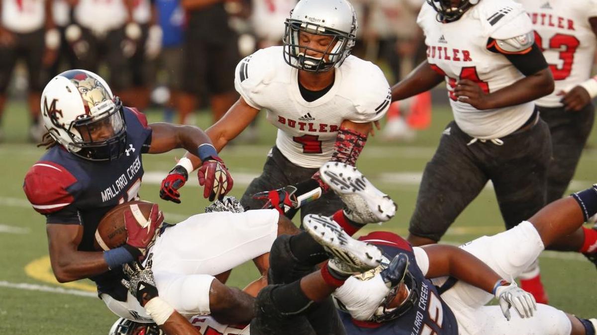 
Mallard Creek ball carrier Chancery Bowman (17) gets caught by the Butler defense during a prep football game at Mallard Creek High School on Friday in Charlotte.
