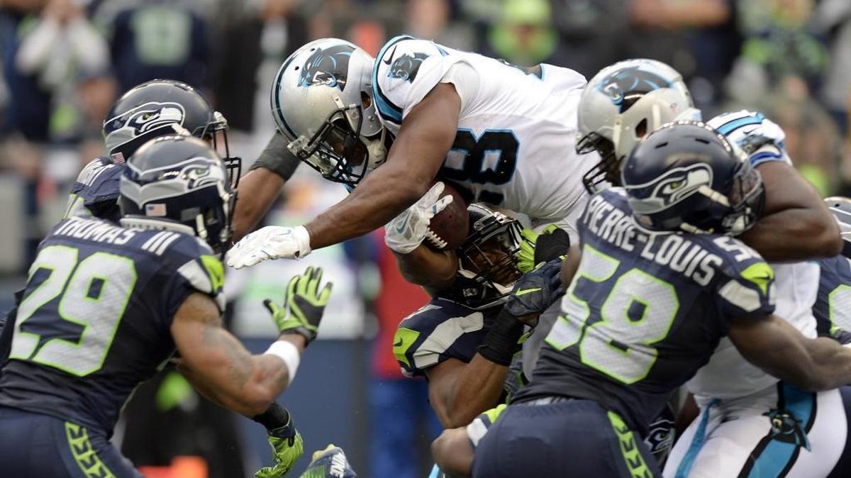 
Carolina Panthers running back Jonathan Stewart (28) dives over Seattle Seahawks defenders for a touchdown during the fourth quarter at CenturyLink Field on Sunday. That score, and the Carolina defense, set up a game-winning drive that gave the Panthers a 27-23 win. 
