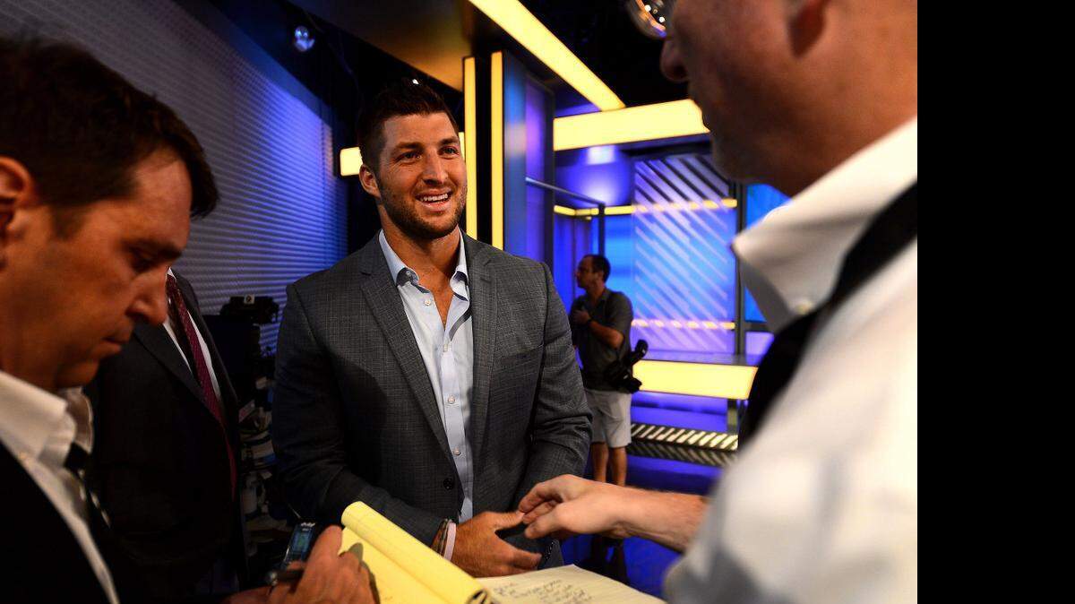 
Tim Tebow, center, shown last August on the set of SEC Nation at an ESPN studio in Charlotte, is getting another shot to play quarterback in the NFL. Monday, the Philadelphia Eagles signed him to a one-year deal. 
