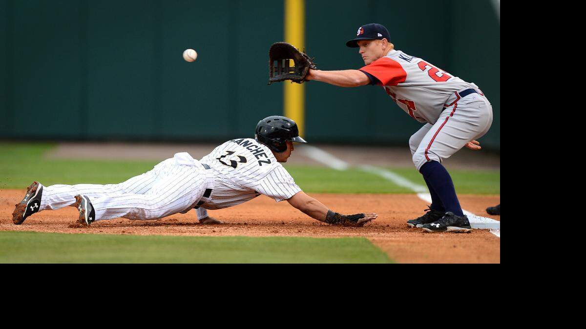 
Charlotte Knights Carlos Sanchez, left, dives back into first base as Gwinnett Braves first baseman Barrett Kleinknecht, right, fields a throw from pitcher Matt Wisler during action at BB&T BallPark on Friday, April 17, 2015.

