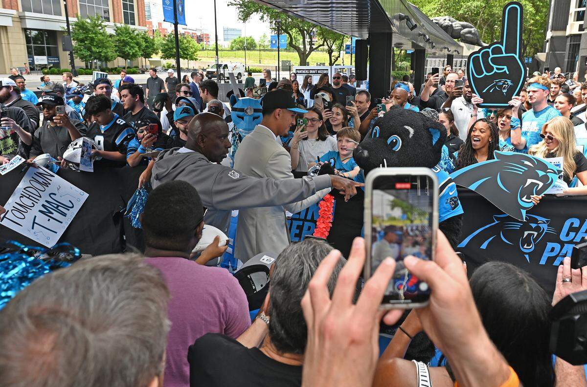 Carolina Panthers draft pick Tetairoa McMillan, center, signs autographs for fans as he walks to the Keep Pounding drum at Bank of America Stadium on Friday, April 25, 2025. The Panthers selected McMillan with the eighth pick in the 2025 NFL Draft.