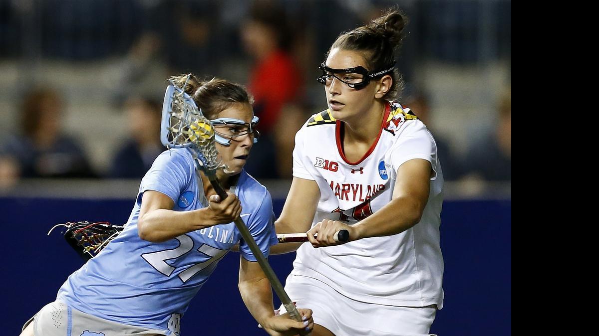 
North Carolina's Aly Messinger (27) moves the ball as Maryland's' Nadine Hadnagy (14) defends during the first half of the championship match in the NCAA Division I women's lacrosse tournament, Sunday, May 24, 2015, Chester, Pa. 
