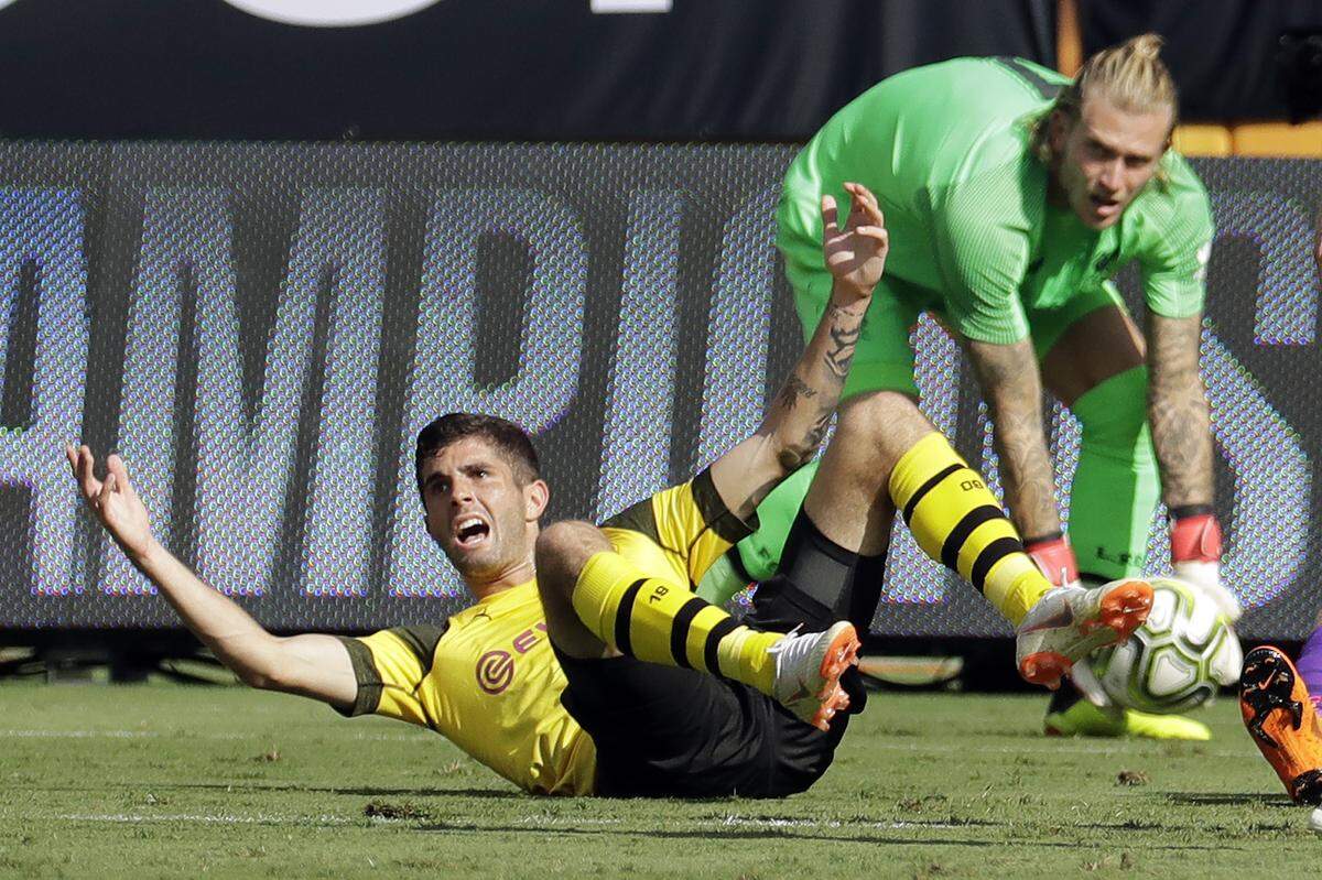 Borussia Dortmund's Christian Pulisic, left, reacts after being fouled as Liverpool goalkeeper Loris Karius, right, grabs the ball during the second half of an International Champions Cup tournament soccer match in Charlotte, N.C., Sunday, July 22, 2018. Pulisic was awarded a penalty kick and scored on the play. (AP Photo/Chuck Burton)