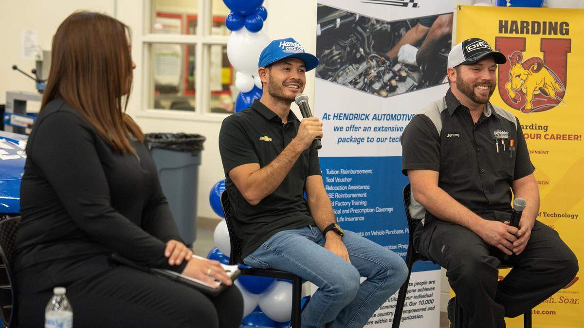 Hendrick Automotive Group’s Chase McBride (left) asks NASCAR Cup Series champion Kyle Larson and City Chevrolet (Hendrick Certified Master Technician) Jeremy Aimi questions about their professions in front of automotive technology students at Harding University High School in Charlotte on Oct. 7, 2022.