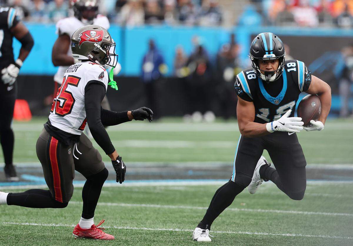 Carolina Panthers' Jalen Coker carries the ball against Tampa Bay Buccaneers' Jacob Parrish on Sunday at Bank of America Stadium.